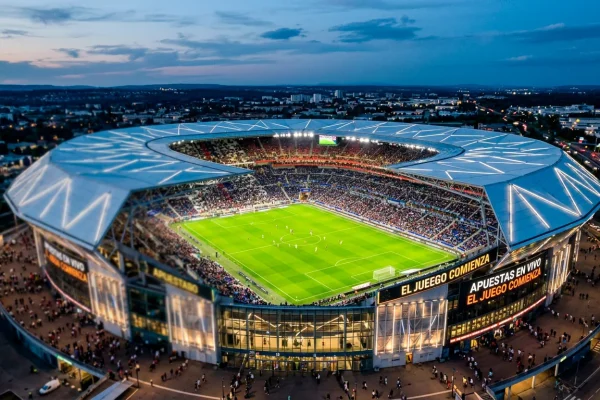 Vista del estadio Groupama del Olympique Lyonnais iluminado durante un partido nocturno de la Ligue 1